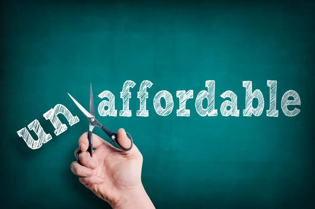 The,Male,Hand,With,Scissors,Cuts,Word,Affordable,From,Unaffordable